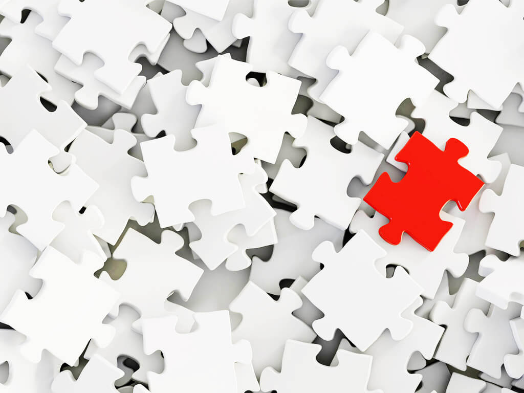 Red puzzle piece among white ones