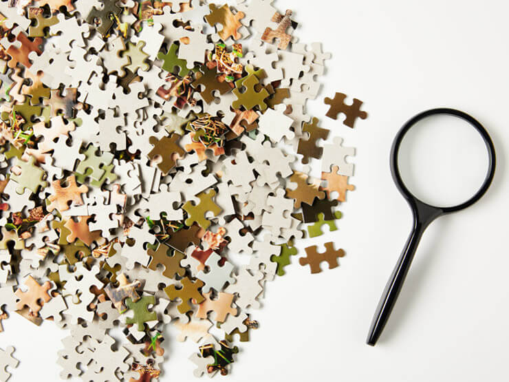 Jigsaw puzzle pieces and a magnifier