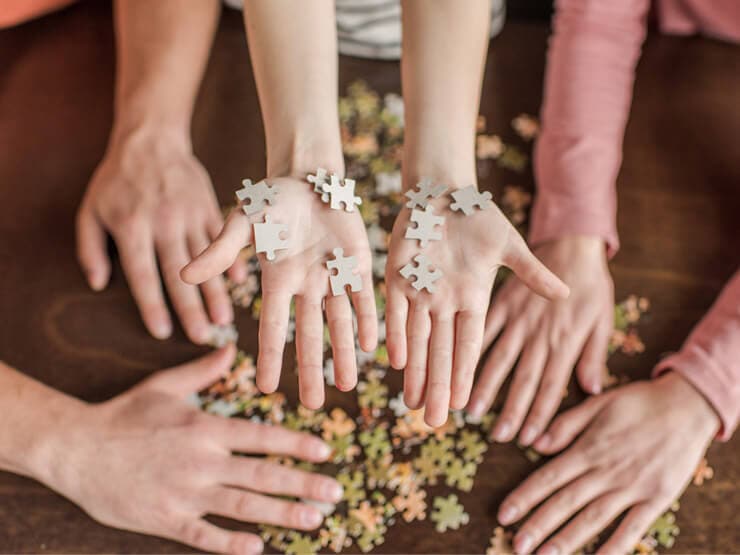 Doing jigsaw puzzles together - view of hands solving a puzzle