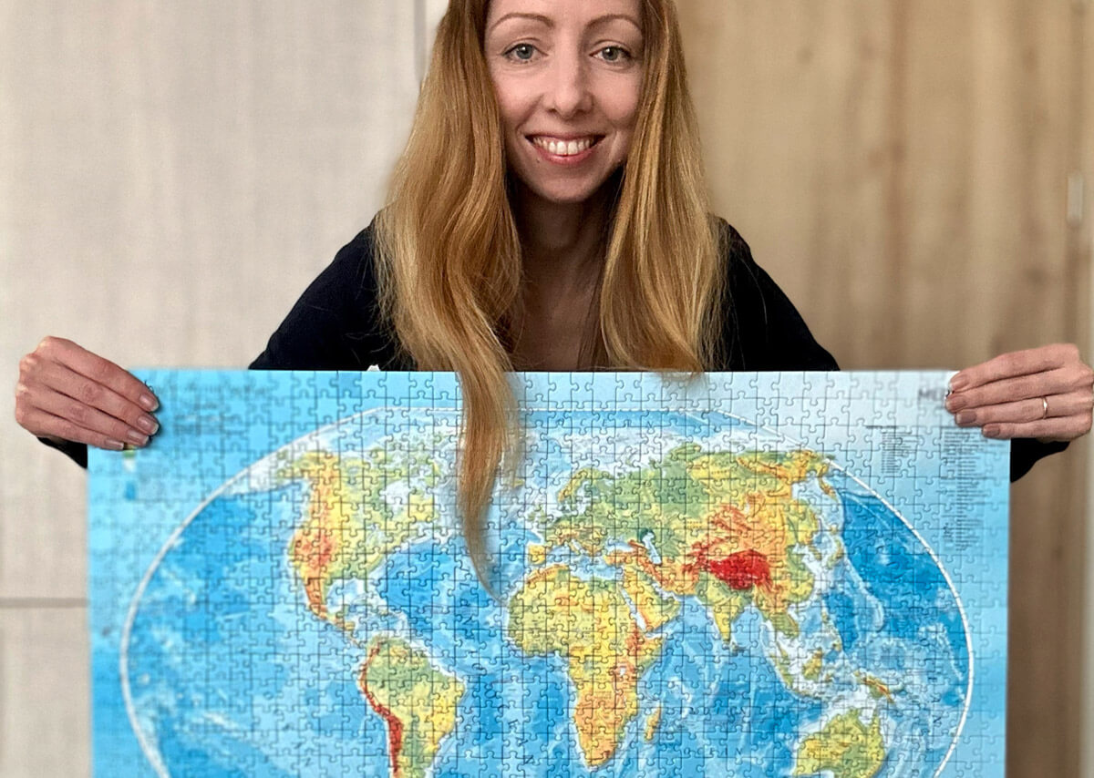 Veronika of JigsawPuzzleQueen holding a finished puzzle of a map